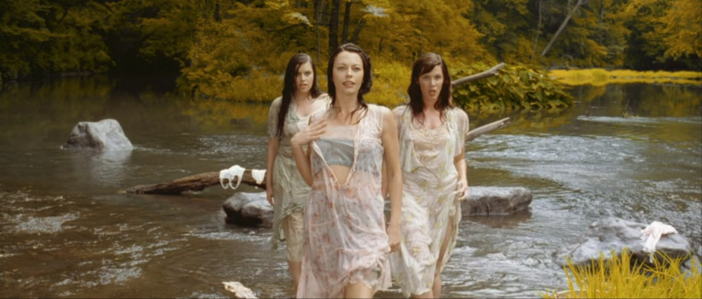 Three women in white dresses stand in a river, still from O Brother Where Art Thou