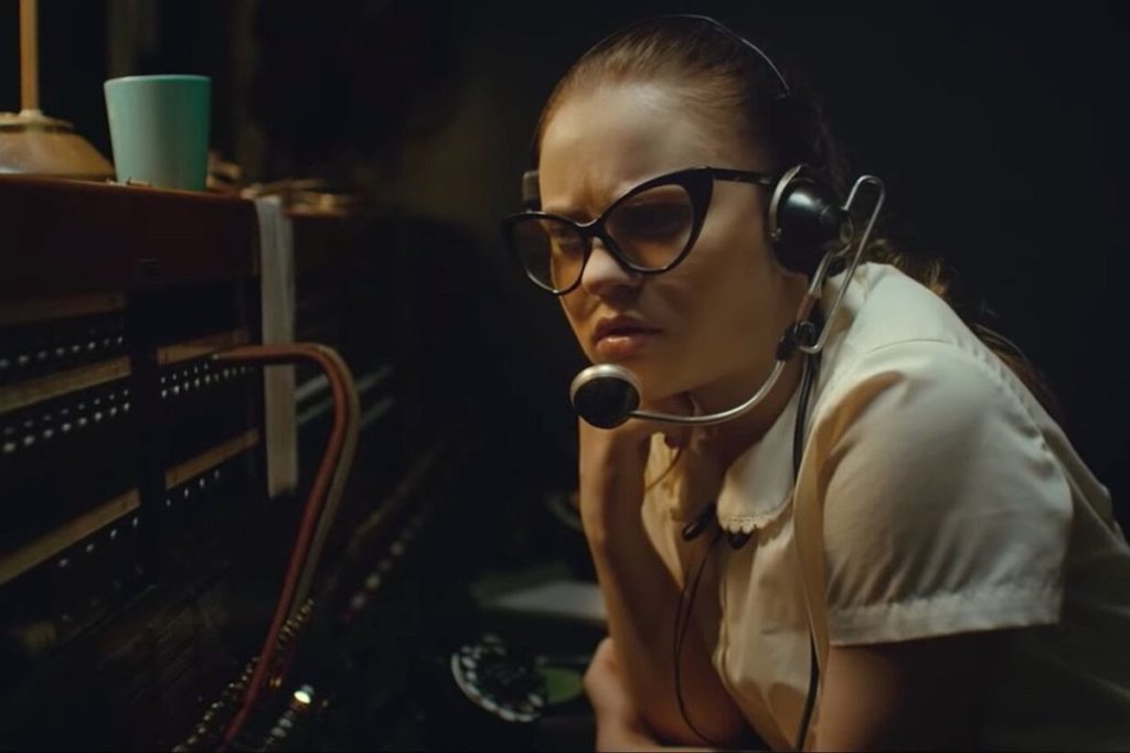 Still from the film The Vast of Night, close up of a teenage girl at a telephone operator switchboard