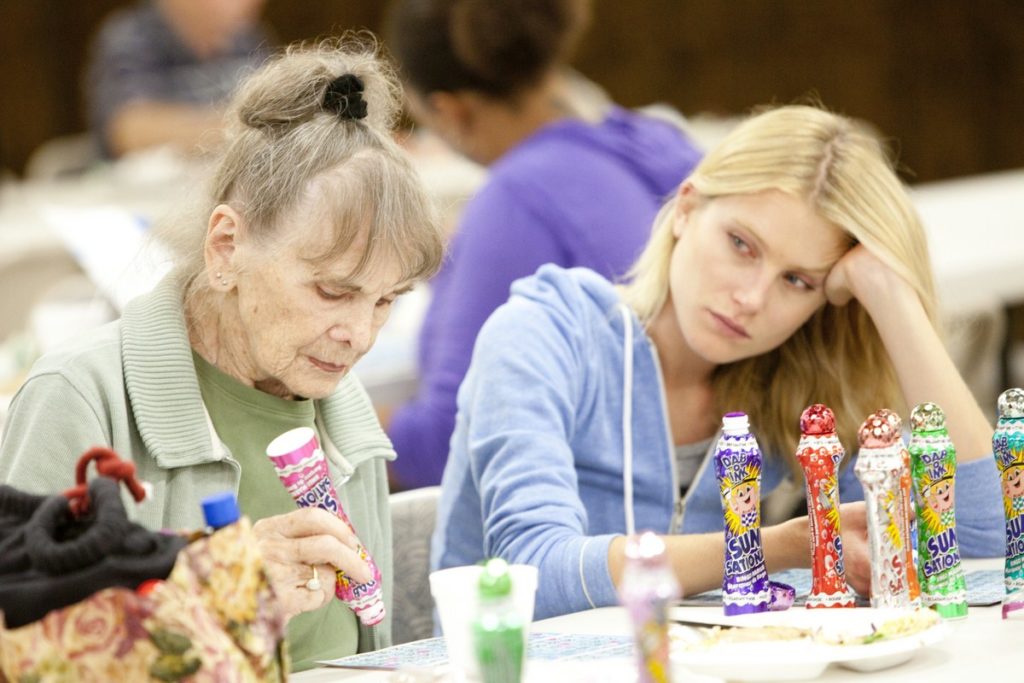 Screen shot from Sean Baker's Starlet, medium shot of an old woman and a young woman doing a craft together